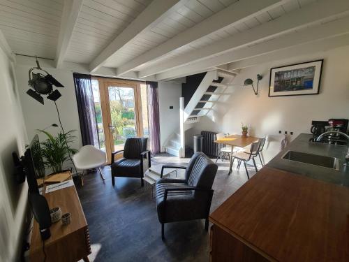 ein Wohnzimmer mit Stühlen, einem Tisch und einer Treppe in der Unterkunft Studio12A in Domburg