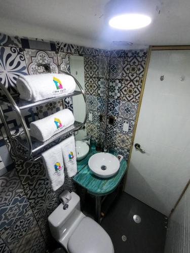 a bathroom with a sink and a toilet and towels at Casa Saphi in Cusco