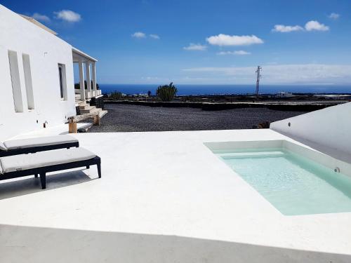 uma piscina em cima de uma casa branca em Apartamento con vistas al oceano em Tías