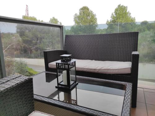a balcony with a bed and a glass table at Paradise Village Port Aventuras in Salou