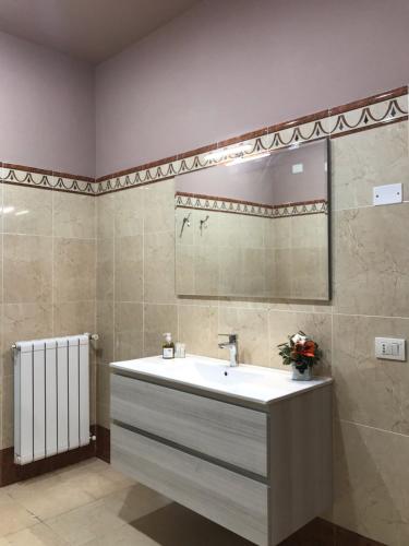 uma casa de banho com um lavatório e um espelho em La Casa di Demetra. Un Paradiso tra gli Olivi. em Montecchio