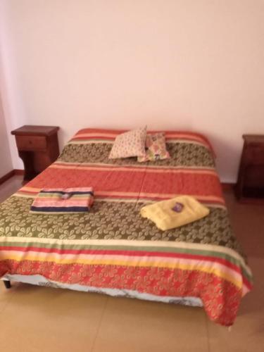 a bed with a blanket and two towels on it at Cabaña Amaya in Tandil