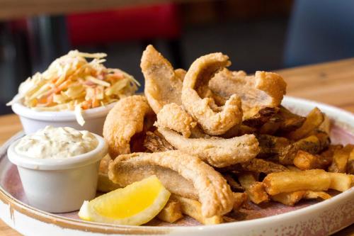 a plate of food with onion rings and coleslaw at Retro Suites Hotel in Chatham