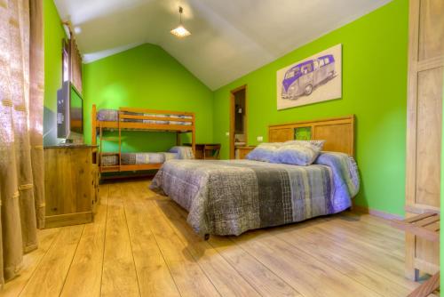 a bedroom with two beds and green walls at Hostal Rural La Tintoreria in Villablino