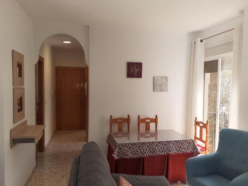 a living room with a table and a couch at Apartamentos Pinos Genil in Pinos Genil