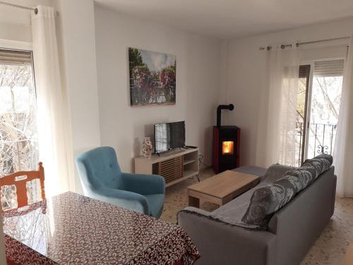 a living room with a couch and chairs and a table at Apartamentos Pinos Genil in Pinos Genil