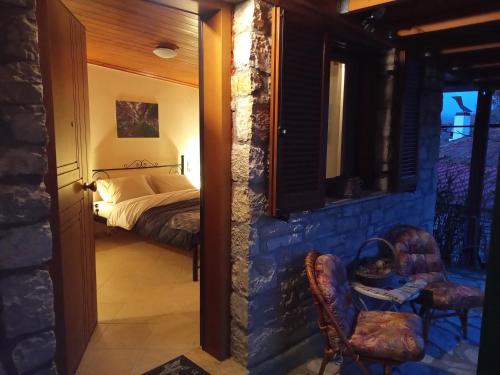 a bedroom with a bed and two chairs at Τείχιο Μπουτίκ - Tihio Boutique - Πέτρινος ξενώνας in Tíkhion