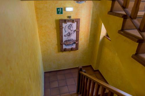 a staircase with yellow walls and a picture on the wall at Hostal Rural La Tintoreria in Villablino