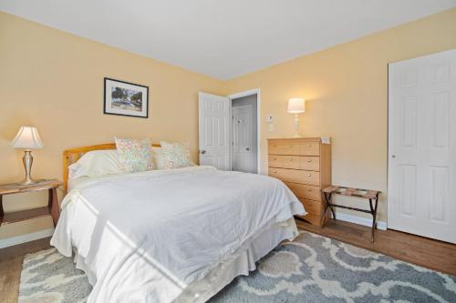 a bedroom with a large white bed and a dresser at ⭐️The Lucky 7 Beach House⭐️Water view⭐️4 bedroom⭐️ in Brigantine