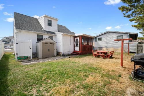 a backyard with a house and a picnic table at ⭐️The Lucky 7 Beach House⭐️Water view⭐️4 bedroom⭐️ in Brigantine