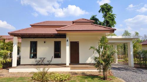 a small house with a brown roof at Isan Golf & Adventure Hotel in Udon Thani