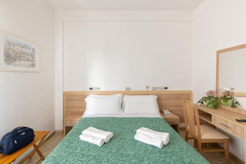 um quarto com uma cama, uma secretária e um espelho. em Hotel Morena Riccione Centrale em Riccione