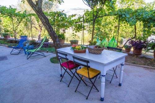 a table with chairs and a bowl of fruit on it at Amalfi Coast, Positano, Sorrento, Capri, Garden, Villa Carcara in Colli di Fontanelle
