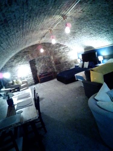 - un salon avec des canapés et un mur en pierre dans l'établissement The Secret Cellar, à Gatehouse of Fleet