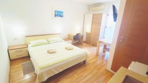 a bedroom with a large white bed and a desk at Apartments Vjeko in Split