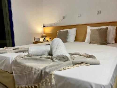 un letto con coperte bianche e asciugamani di Elgreco Apartment, at Tigaki, near the sea "2" a Città di Kos