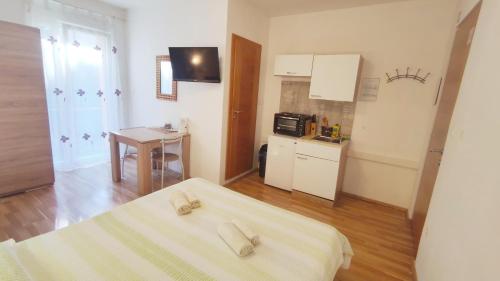 a small room with two beds and a kitchen at Apartments Vjeko in Split