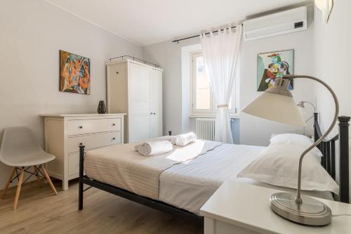 1 dormitorio con 1 cama y escritorio con lámpara en Apartment delle Rose - Menaggio, en Menaggio