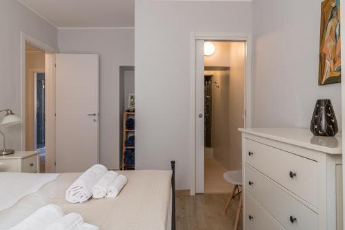 a white bedroom with towels on a bed at Apartment delle Rose - Menaggio in Menaggio