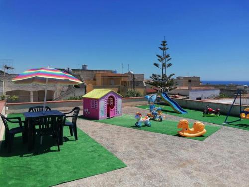 a playground with a table and children on the grass at La Dolce Oasi in Triscina
