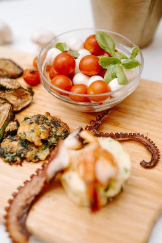 a wooden cutting board with a bowl of vegetables and a snake at Hotel Da Felice in Bopfingen