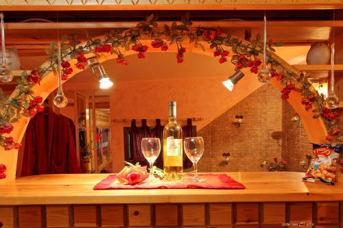 a bottle of wine and two glasses on a table at Under the Walnut Tree Shade Lodge in Adi