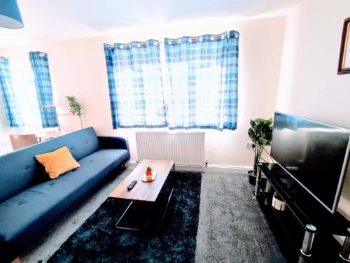 a living room with a blue couch and a tv at Crystal Suite 3 Free Private Parking in South Shields