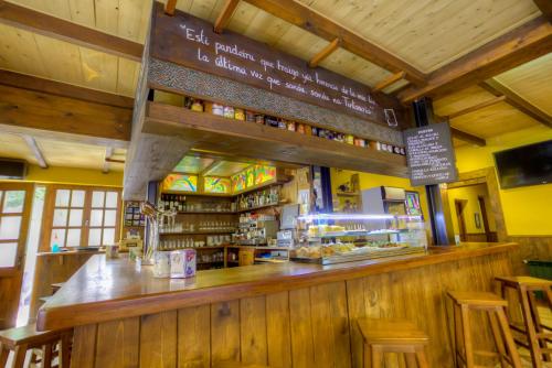 a bar in a restaurant with a sign above it at Hostal Rural La Tintoreria in Villablino