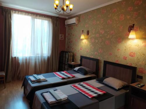 two twin beds in a room with a window at N38 in Tbilisi City