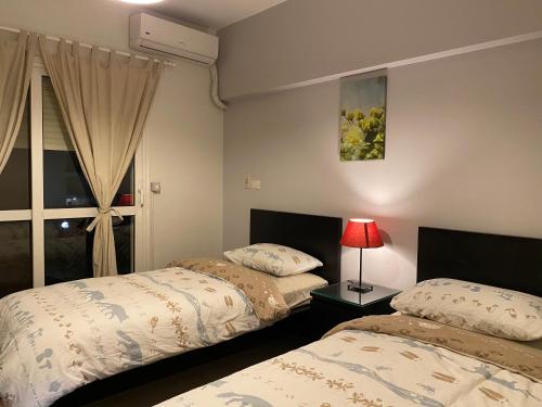 um quarto com 2 camas e uma janela em Al-Rehab luxury apartment no Cairo