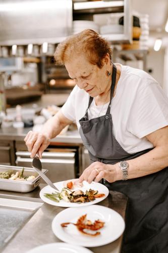 a woman in a kitchen preparing a plate of food at Hotel Da Felice in Bopfingen