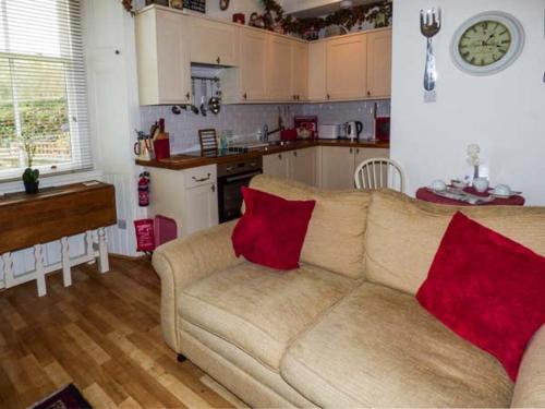 a living room with a couch with two red pillows at 3 Queen Marys Buildings in Jedburgh