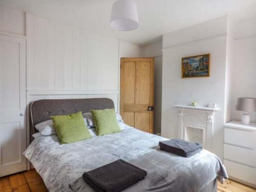 a bedroom with a large bed with green pillows at Dutch Cottage in Colchester