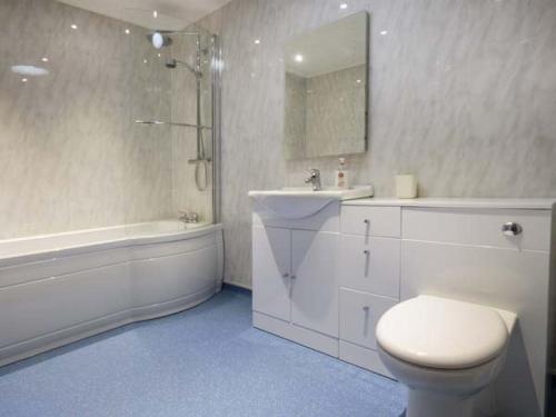 a bathroom with a toilet and a sink and a tub at Ysgubor Newydd in Cemaes Bay