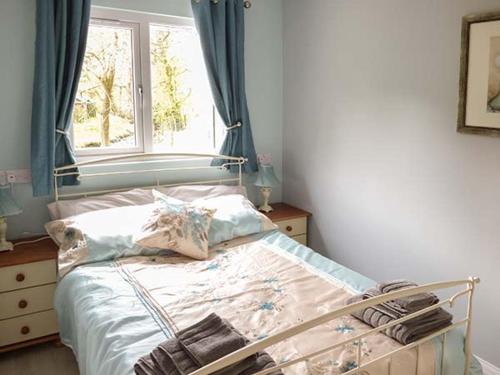 a bedroom with a bed with a window and a window at Park Brook Retreat in Scorton