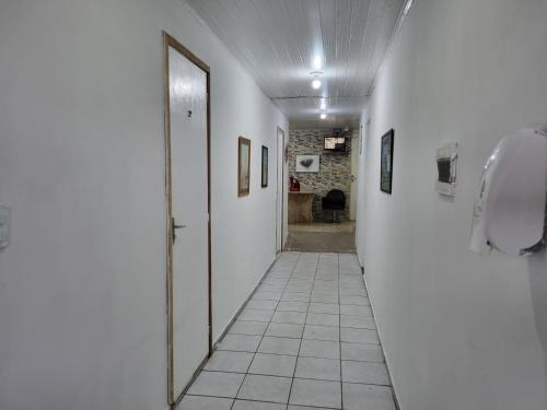 a hallway with a mirror and a phone on a wall at Casa Aeroporto Pousada in Recife