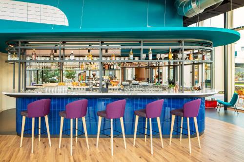 a kitchen with a table, chairs, and tables at YOTEL Amsterdam in Amsterdam