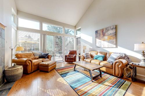 a living room with leather couches and a table at Creekside Comfort in Redmond