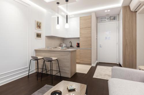 a kitchen and living room with a counter and stools at A Blok Top Living in Belgrade