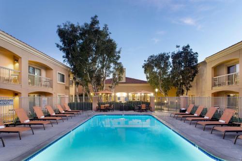 une piscine avec des chaises longues et un hôtel dans l'établissement Sonesta Select Camarillo, à Camarillo
