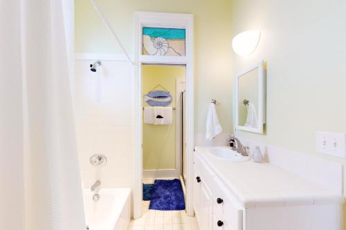 ein weißes Badezimmer mit einem Waschbecken und einem Spiegel in der Unterkunft Destin Dolphin in Destin