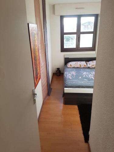 a small bedroom with a bed and a window at Appartement Blagnac in Blagnac