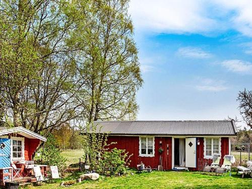 una casa roja y blanca con sillas delante en 5 person holiday home in TOSTARED, en Tostared