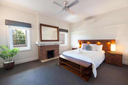 Schlafzimmer mit einem Bett, einem Kamin und einem Spiegel in der Unterkunft The Bank Apartment - Echuca Holiday Homes in Echuca