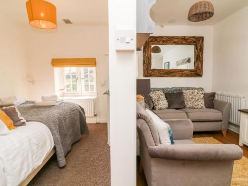 uma sala de estar com uma cama e um sofá em Robin Cottage em Ilfracombe