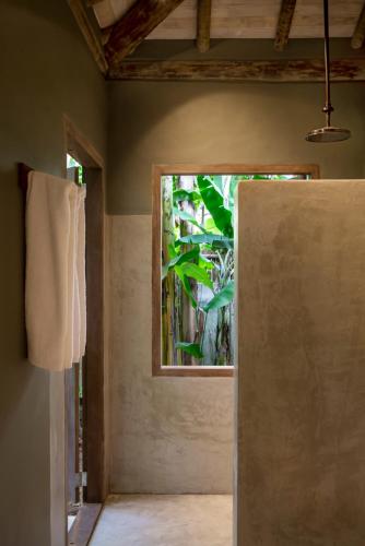 an open door to a room with a window at Casa Das Águas Trancoso in Trancoso