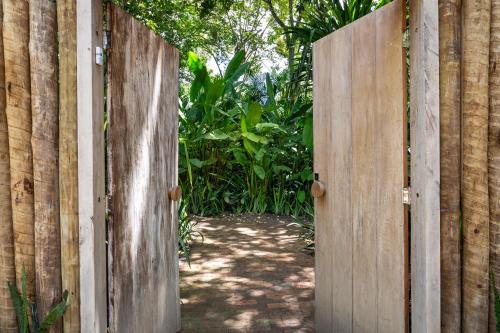un portail ouvert dans une clôture en bois avec un chemin dans l'établissement Casa Das Águas Trancoso, à Trancoso