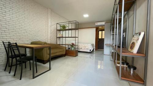 a living room with a table and a bedroom at Loft amplo, apenas 6km do Morro do Careca! (G) in Natal