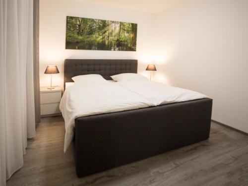 a bedroom with a large bed with white sheets at Appartements mit Blick auf die Spree in Lübben in Lübben