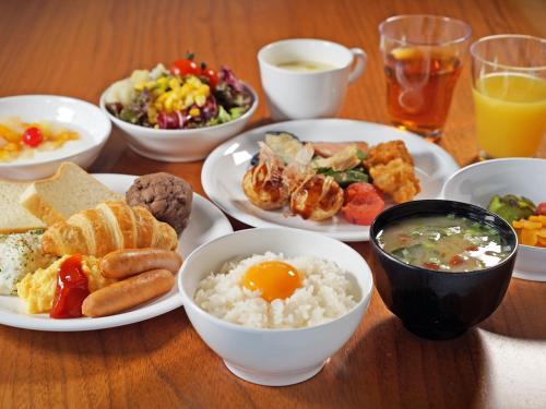 a table with plates of breakfast foods and drinks at CHISUN STANDARD Osaka Shin-Imamiya in Osaka